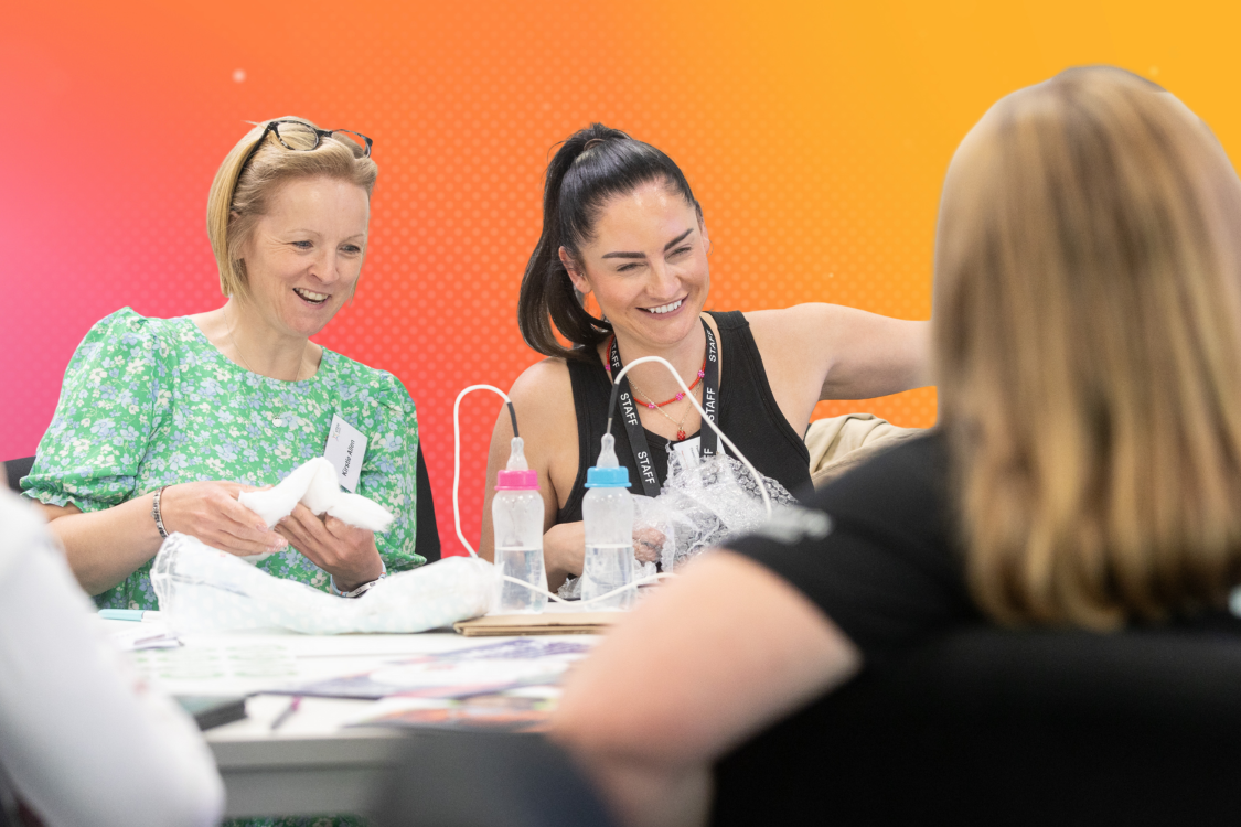 Hands-on activity at Inspiring STEM 2026 schools event showing participants with training props